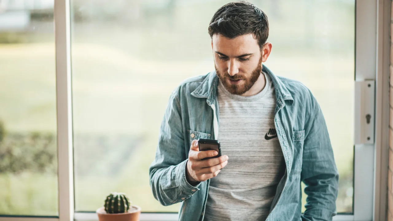 Hombre viendo un video de YouTube en su celular