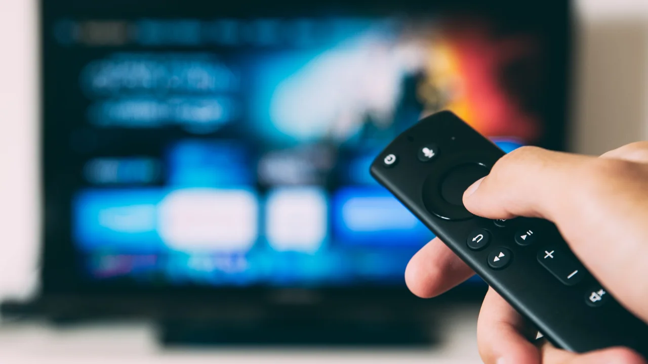 Remote control TV menunjuk ke layar