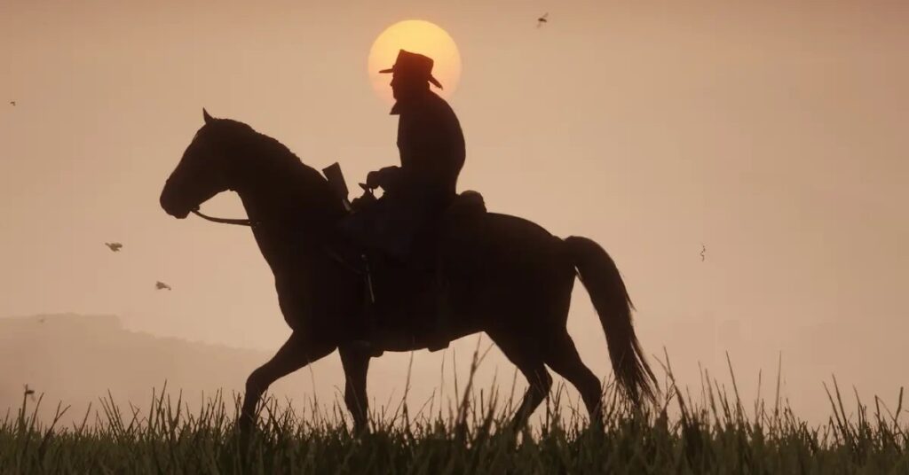 Man is on top of his horse, riding in the field at sunset 