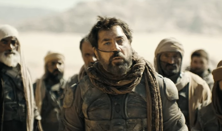 El actor Javier Bardem es representado como un guerrero del desierto, de aspecto cansado y una gran barba negra, con armadura oscura, un pañuelo manchado de arena y un pequeño respirador en la nariz. El escenario es el desierto al mediodía, con otros guerreros con el mismo atuendo al fondo.
